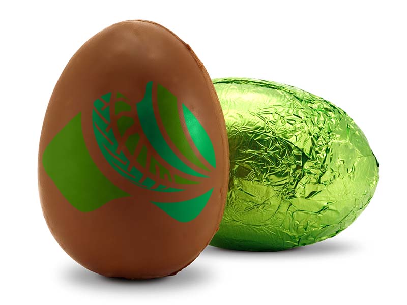 Chocolate easter egg sitting beside a green foil easter egg