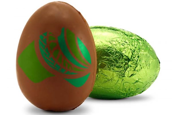 Chocolate easter egg sitting beside a green foil easter egg